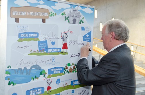 Bill Walker MSP signs community volunteering campaign banner